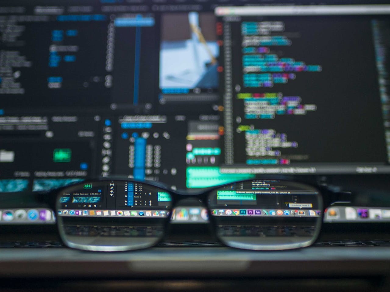 services-01 Eyeglasses reflecting computer code on a monitor, ideal for technology and programming themes.